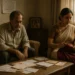 An Indian middle-aged couple sitting in a modest home, surrounded by old furniture and silent tension.