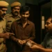 Madhab in handcuffs with Railway Police constables intimidating a frightened man holding money.
